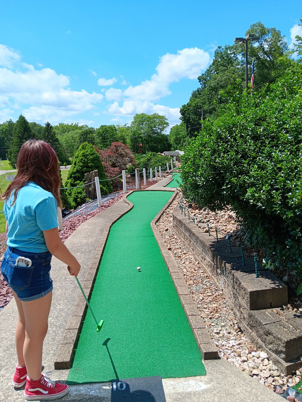 Guest putting on a beautifully landscaped mini golf green